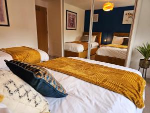 a bedroom with two beds and a mirror at Homebird Property - Epsom Apartment in Harrogate