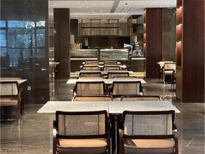 a dining room with tables and chairs in a restaurant at Ramada by Wyndham Taizhou West in Taizhou