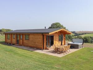 a log cabin with a picnic table and a barbecue at Bluebell Lodge in Exeter