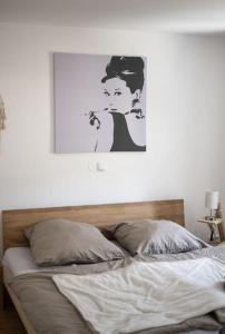 1 cama en un dormitorio con una foto en la pared en Wohnwerk: Das Moselhaus, direkt Grenze Luxemburg, en Oberbillig
