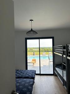 - une chambre avec un lit et une vue sur la piscine dans l'établissement Villa de Groupe avec Piscine, Jacuzzi et Vue Nature, à Pierric