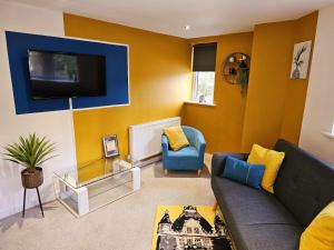 Homebird Property - Epsom Apartment في هاروغايت: غرفة معيشة مع أريكة وتلفزيون