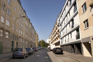 una calle con coches estacionados a los lados de los edificios en Modern - Calm - Cozy - self CheckIn - stylish new apartment near center - close to U4, en Viena
