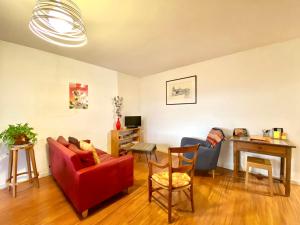a living room with a red couch and a table at La Garonne - T3 avec parking privé in Toulouse