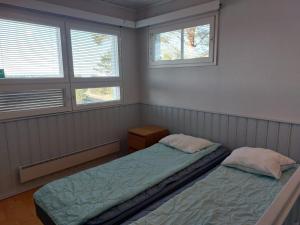 1 Schlafzimmer mit 2 Betten und 2 Fenstern in der Unterkunft Merimaisema 6 in Kalajoki