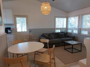 ein Wohnzimmer mit einem Sofa, einem Tisch und Stühlen in der Unterkunft Merimaisema 6 in Kalajoki