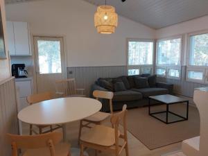 a living room with a couch and a table and chairs at Merimaisema 6 in Kalajoki