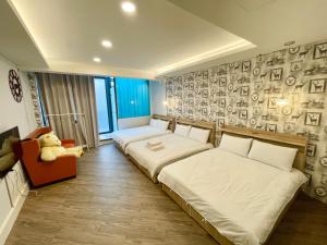a bedroom with a bed and a couch and a chair at Fengchia Provence in Taichung