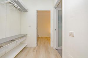 un corridoio con pareti bianche e pavimento in legno massello di MILAN MCHOME a Trezzano sul Naviglio
