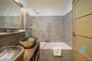 baño con bañera grande y lavamanos en Chez Stella 3 chambres neuf plein centre en Huez