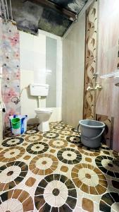 uma casa de banho com WC e piso em azulejo em HAPPY PLACE HAMPI em Hampi