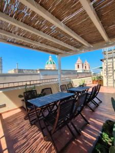 a patio with tables and chairs on a deck at Palazzo Dei Corsari in Trapani