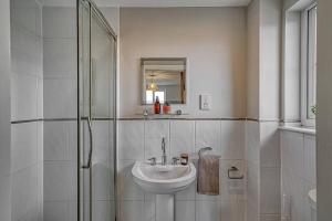 a white bathroom with a sink and a shower at Haigh Park View - WiFi, Parking DW Stadium & Hospital in Standish