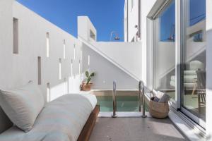 a balcony with a couch next to a window at ALERÓ Seaside Skyros Resort in Skiros