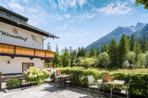 un patio con mesas y sillas frente a un edificio en Wörndlhof - Das Refugium, en Ramsau