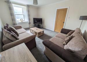 a living room with two couches and a coffee table at 2 Bedroom Townhouse on NC500, Wick, Highland in Wick