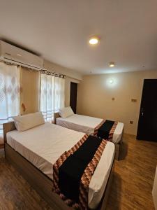 a hotel room with two beds and a television at Hotel Durbar Side in Bhaktapur