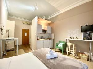 a small room with a bed and a kitchen at Les Capitole I - Studio avec climatisation in Toulouse