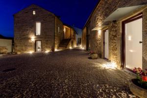 una calle adoquinada con 2 edificios de piedra por la noche en in Bulla, Country and Wellness, 