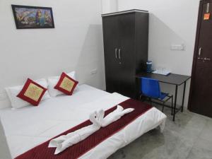 a bedroom with a bed and a desk and a chair at Ashish Guest House, Goverdhan Vilas in Udaipur
