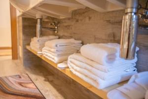 a bunch of towels on a shelf in a bathroom at Bait da Menego in Livigno