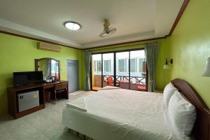 Schlafzimmer mit einem Bett, einem TV und einem Balkon in der Unterkunft Me Mee Place & Tour Krabi in Ao Nang Beach