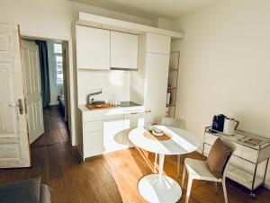 eine kleine Küche mit einem weißen Tisch und Stühlen in der Unterkunft Sommerloft Norderney in Norderney