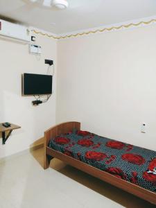 a bedroom with a bed and a tv in a room at Le Grace Mansion in Madurai
