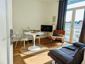 ein Wohnzimmer mit einem Tisch und einem Sofa in der Unterkunft Sommerloft Norderney in Norderney