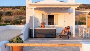 two women sitting on the patio of a house at Anthemion Paros - Villas & Suites in Agia Irini Paros