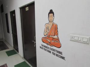 a painting of a monk on a wall in a room at Ashish Guest House, Goverdhan Vilas in Udaipur