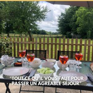 una mesa con tazones y copas de vino encima en Grand Gite ideal pour famille 10 personnes , 3chambres , 10 couchages en Criquiers