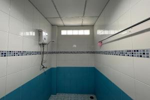 La salle de bains est revêtue de carrelage bleu et blanc. dans l'établissement Me Mee Place & Tour Krabi, à Ao Nang Beach
