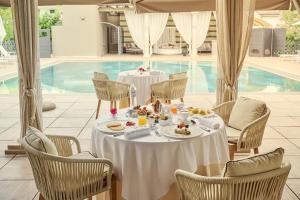 un tavolo con cibo accanto a una piscina di Grand Hotel Imperiale - Preferred Hotels & Resorts a Forte dei Marmi
