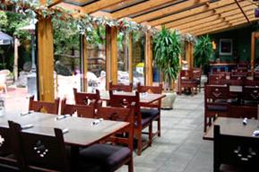 ein Restaurant mit Holztischen, Stühlen und Pflanzen in der Unterkunft Bozeman Inn in Bozeman
