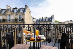 a table with a bowl of bread and a cup of orange juice at Padam Hôtel in Paris