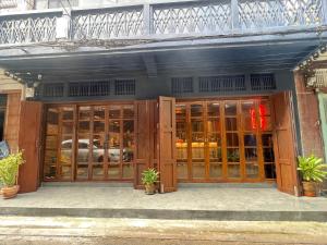 einem Laden mit Holztüren und Topfpflanzen in der Unterkunft Ci home in Pom Prap