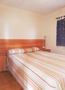 1 dormitorio con 1 cama grande y cabecero de madera en Camping Naturista El Portús - Nudist FKK en Cartagena