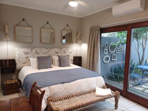 a bedroom with a large bed and a large window at Klipkoppie Cottage in Nelspruit