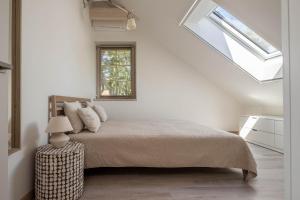 a white bedroom with a bed and a window at Nauji apartamentai! Pamario 14 in Nida