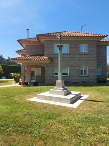 a building with a statue in front of a house at Os Cabaleiros in Mos