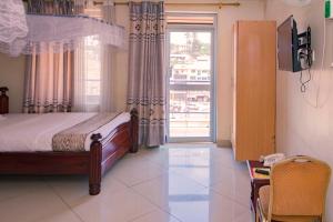 a bedroom with a bed and a large window at G-ONE HOTEL in Kampala