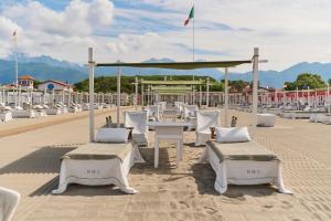un gruppo di tavoli e sedie su una spiaggia di Grand Hotel Imperiale - Preferred Hotels & Resorts a Forte dei Marmi