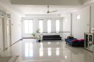 uma sala de estar com 2 sofás e uma ventoinha de tecto em Rumah Teuku Umar Mitra RedDoorz em Kedongdong