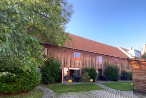 un gran edificio de madera con techo rojo en Himmel & Hölle Ferienhäuser en Quedlinburg