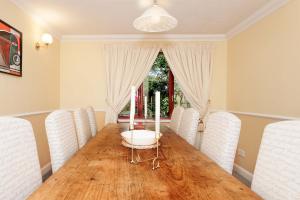 a dining room with a wooden table and white chairs at Spring Close in Colchester