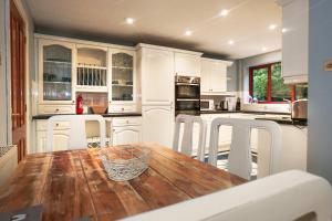 a kitchen with a wooden table and white cabinets at Spring Close in Colchester