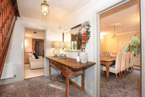 a dining room with a table with a vase of flowers on it at Spring Close in Colchester