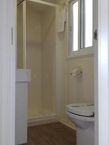 a bathroom with a toilet and a window at Camping Naturista El Portús - Nudist FKK in Cartagena