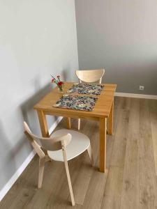 a wooden table with two chairs and a table with a rug at Gallusa Apartament in Katowice